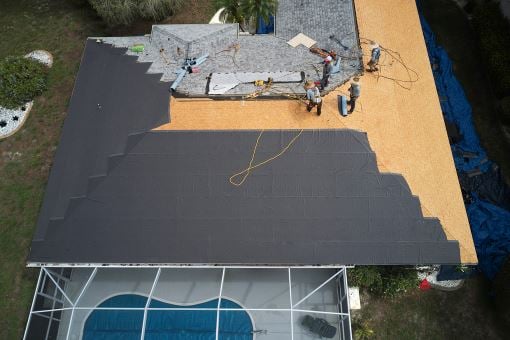 Aerial view of roofing contractors working on roof