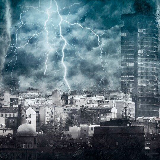 Cityscape with towering buildings under a stormy sky. Bright lightning forks illuminate dark clouds, conveying a tense, energetic atmosphere.
