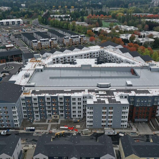 An aerial perspective of a modern, multi-story apartment complex.