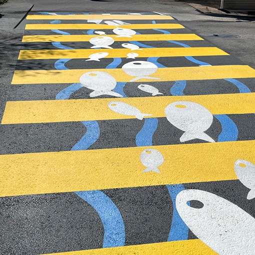 Fish and wave pattern on pavement created with StreetBond pavement coatings