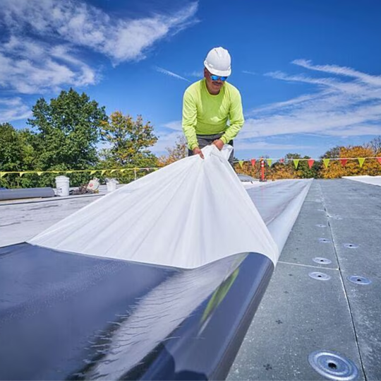 GAF certified contractors unrolling and positioning a self-adhered GAF EverGuard SA TPO membrane.