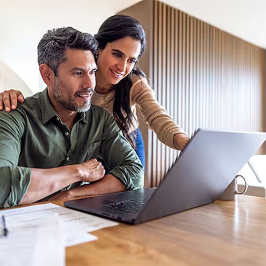 Homeowners reviewing roof warranty options on their laptop