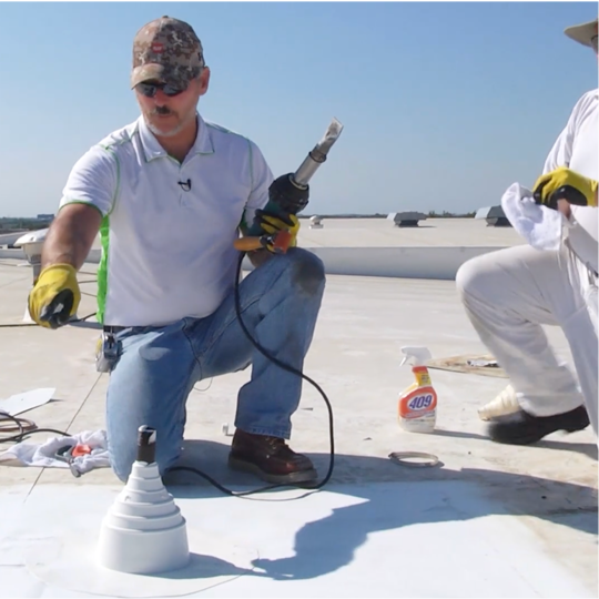 Wally Brown using a heat-welding tool to repair a TPO roof accessory exposed to machine oil.