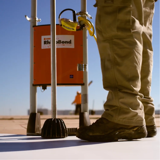 A GAF certified contractor using a induction welder on a roof deck.