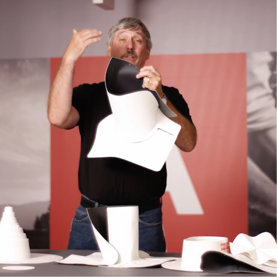 Wally Brown demonstrating how to fit prefabricated TPO accessories during a training presentation.