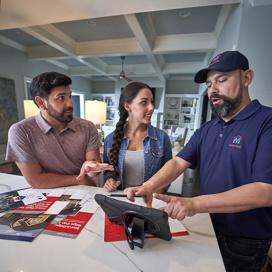 Roofing contractor educating homeowners on how to plan for their roof replacement.