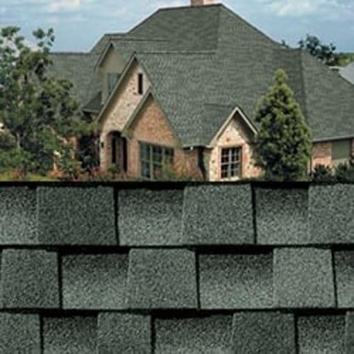 GAF Timberline HDZ slate shingle closeup with sample product image on a light brick house.