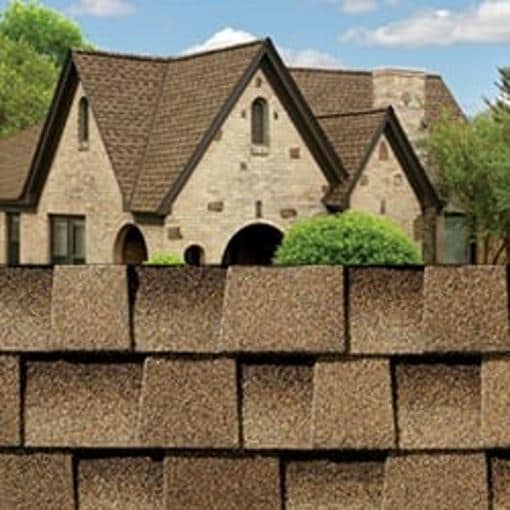 GAF Timberline HDZ shakewood shingle closeup with sample product image on a light brown brick house.