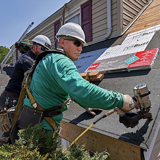 GAF certified roofing contractors installing starter strip shingles.