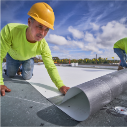 Roofer adding GAF guarantee commercial materials to a flat roof