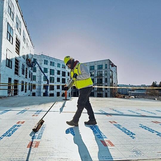 GAF certified commercial roofing contractor installs GAF product on a flat roof.