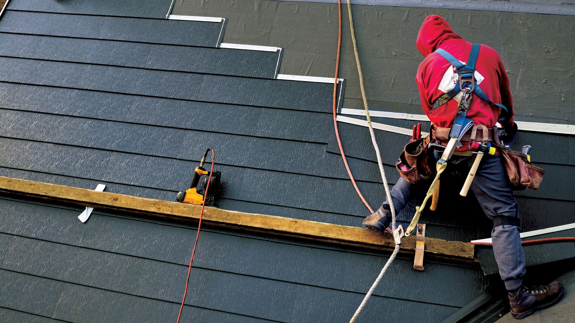 Roofing contractor installing TimberSteel metal roof shingles with standard roofing equipment