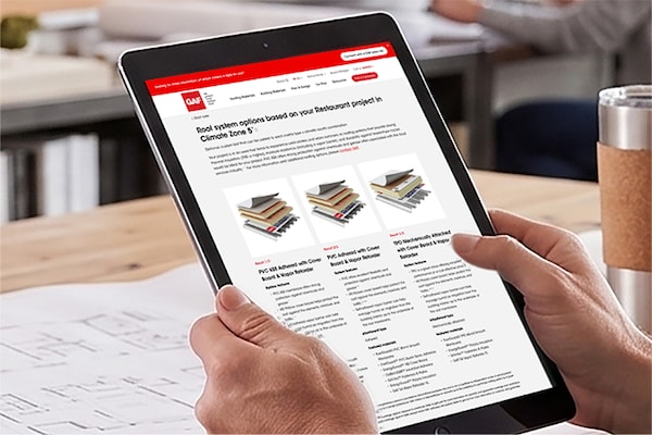 A user reviewing customized commercial roof assembly options on a tablet using the GAF Commercial Roof Selector tool.