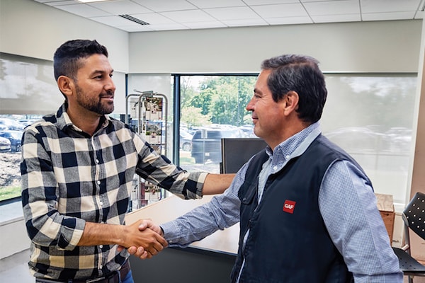 A contractor gets more information about  the GAF Community Contractor program from a GAF representative.
