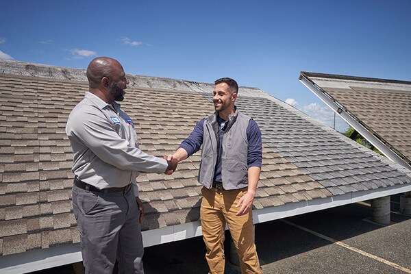 A GAF roofing products distributor and a contractor shaking hands