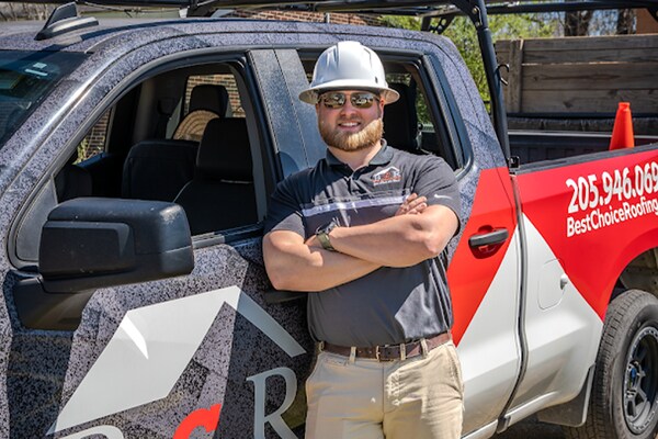 Best Choice roofing professional standing beside his branded company vehicle.