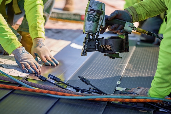 Roofing contractor installing tiles as part of a solar roofing system.