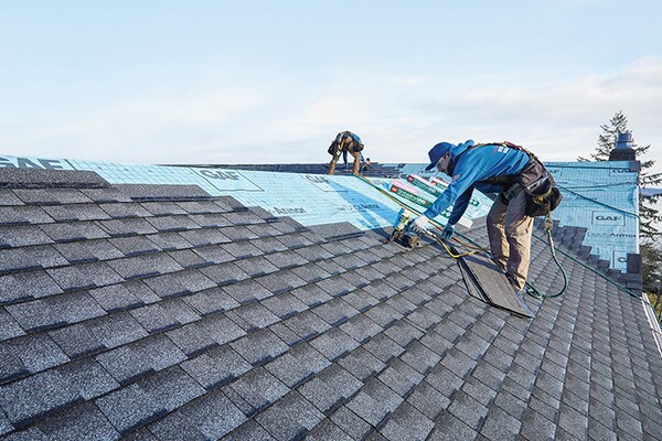 A GAF-certified roofer installing a FORTIFIED Roof system on top of a house. 