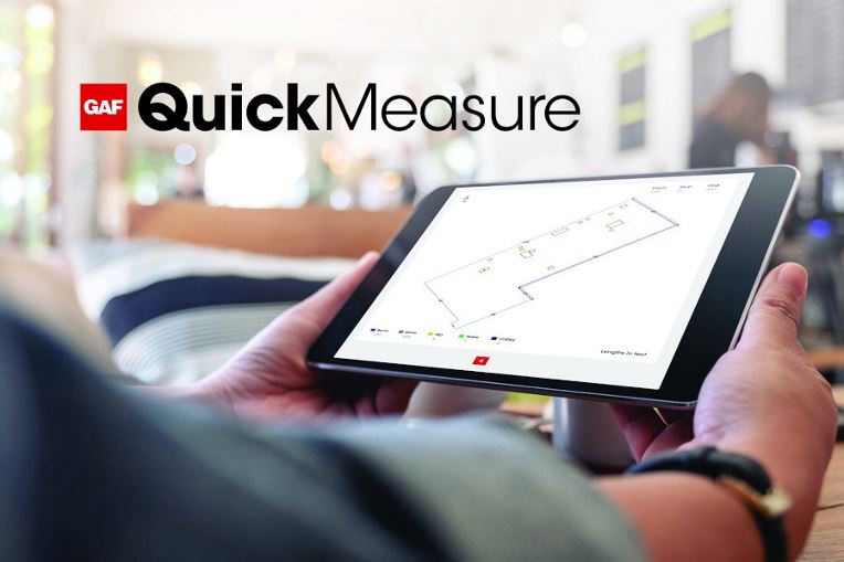 Contractor using GAF QuickMeasure on tablet to get commercial roof measurements