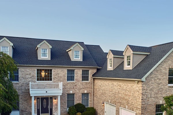 Gray Class 3 roof shingles from GAF on a light brick house.