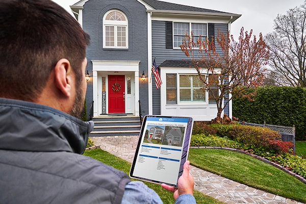 Roofer outside residential home using QuickSite on a tablet