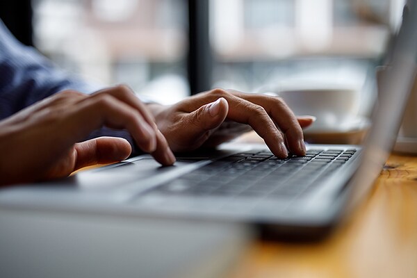 Hands typing on a laptop, scheduling a demo with GAF.