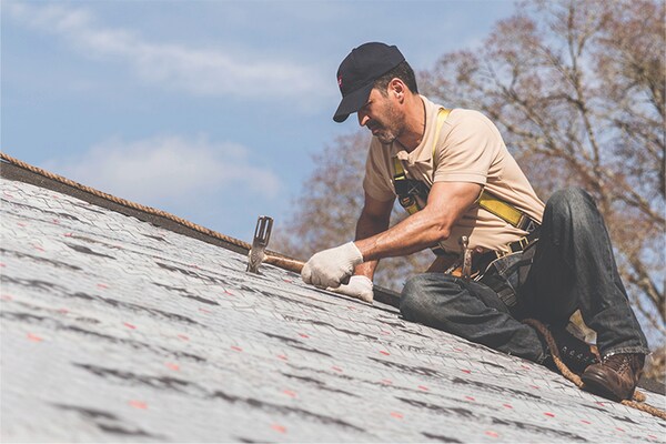 GAF certified roofing contractor installing a synthetic underlayment on a roof. 