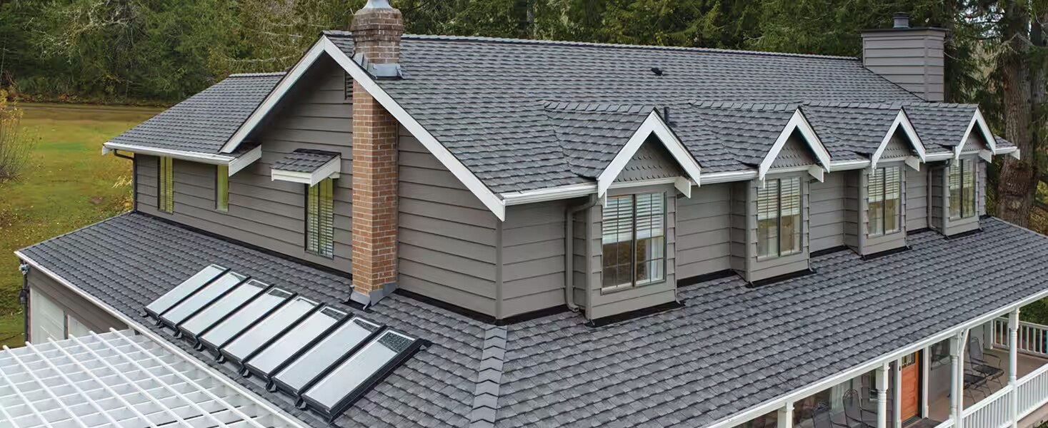 GAF contractor standing next to pile of GAF Timberline UHZD premium shingles in wrappers.