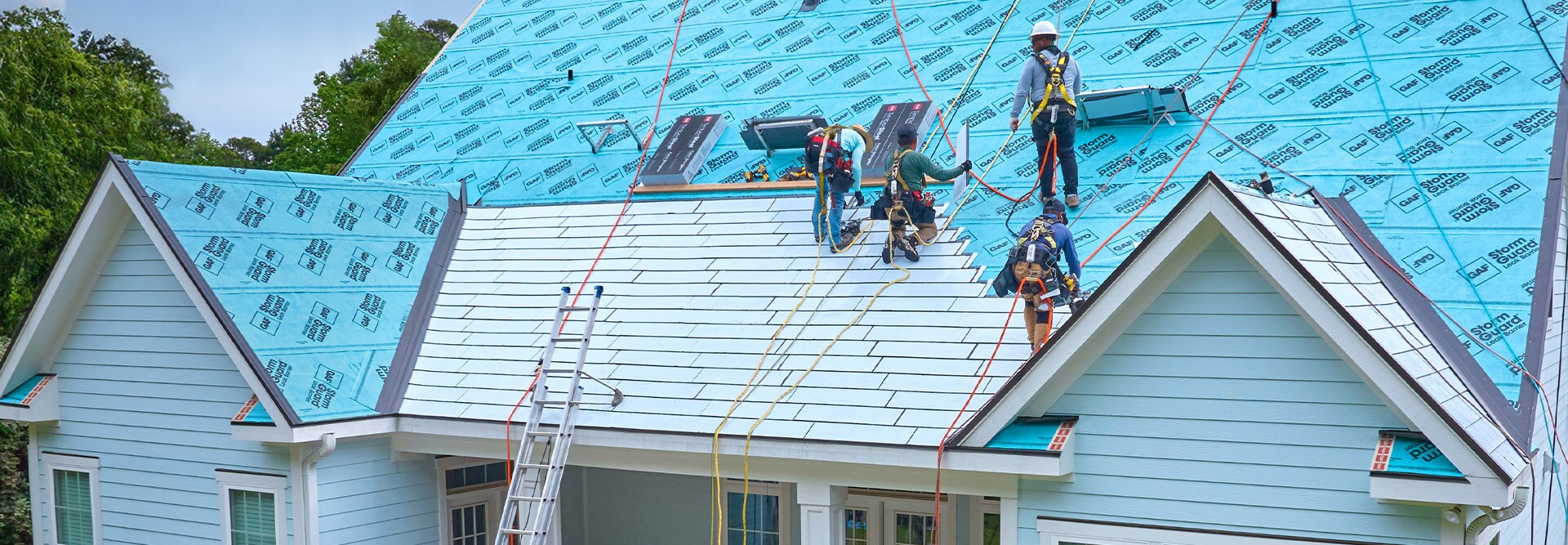 GAF certified contractors standing on a rooftop installing the TimberSteel Metal Roofing System. 