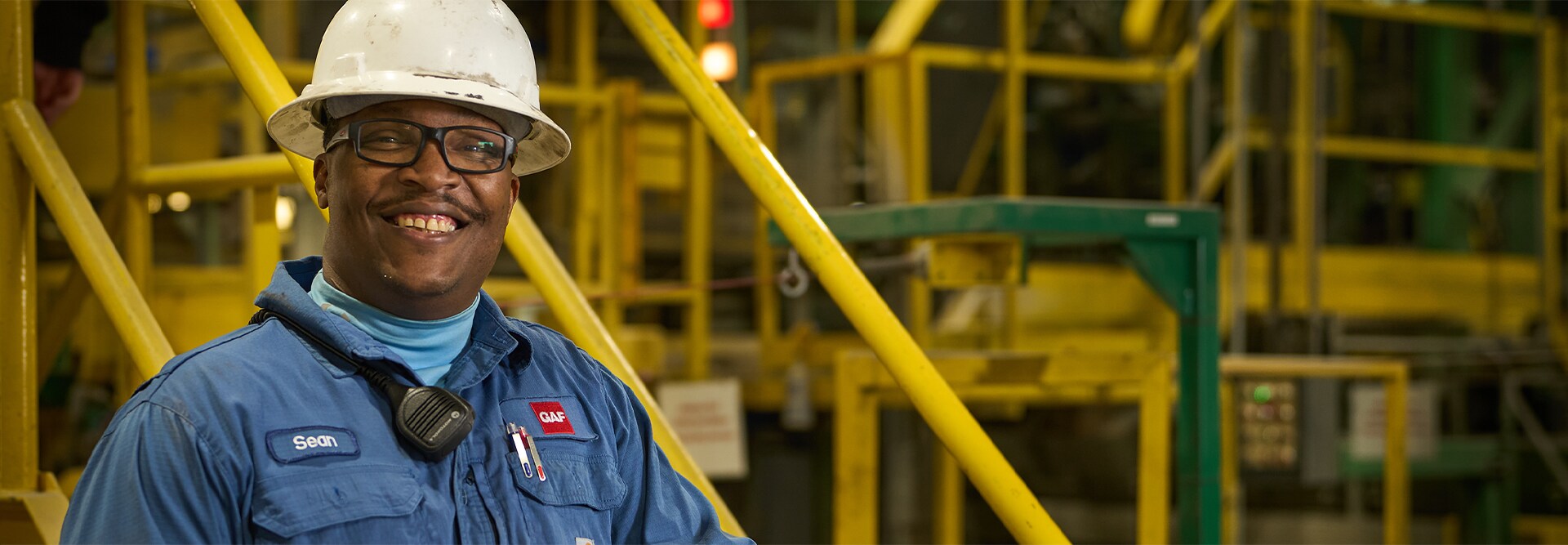 GAF employee wearing a hard hat and a GAF brand jacket at the Fontana plant.