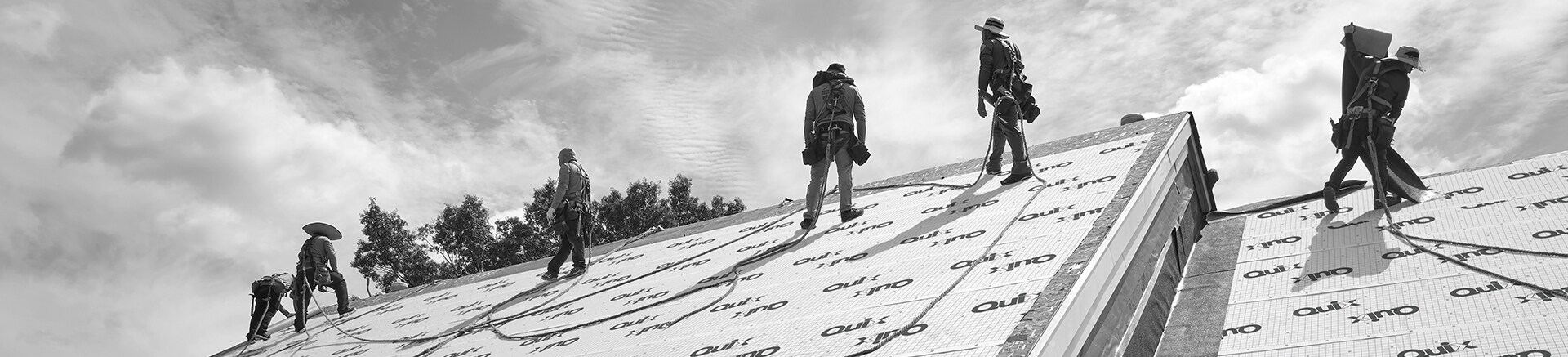 Contractors installing Quix™ Underlayment on a roof.