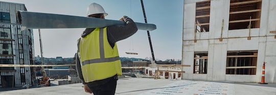 Contractor holding roofing materials walking on the roof of the Revington