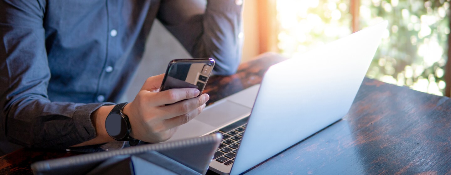 Person with laptop and phone reaching out to customer service