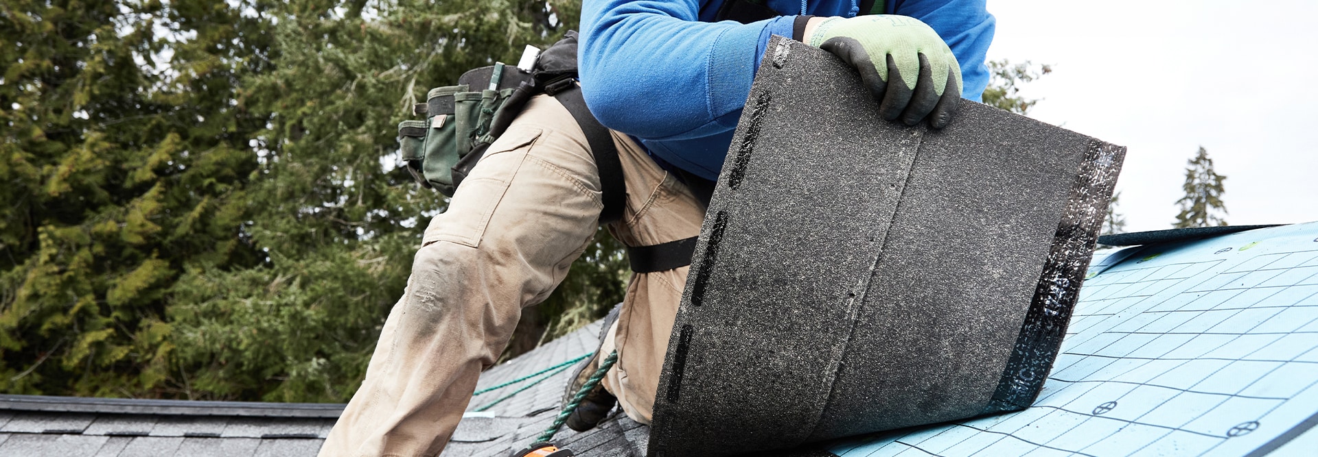 Contractor installing Timberline HDZ shingles over deck-armor laying down shingle