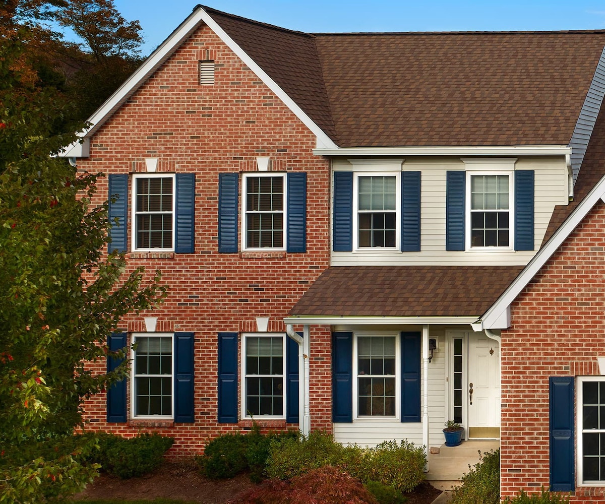 Brick and white home with Amber roof shingles