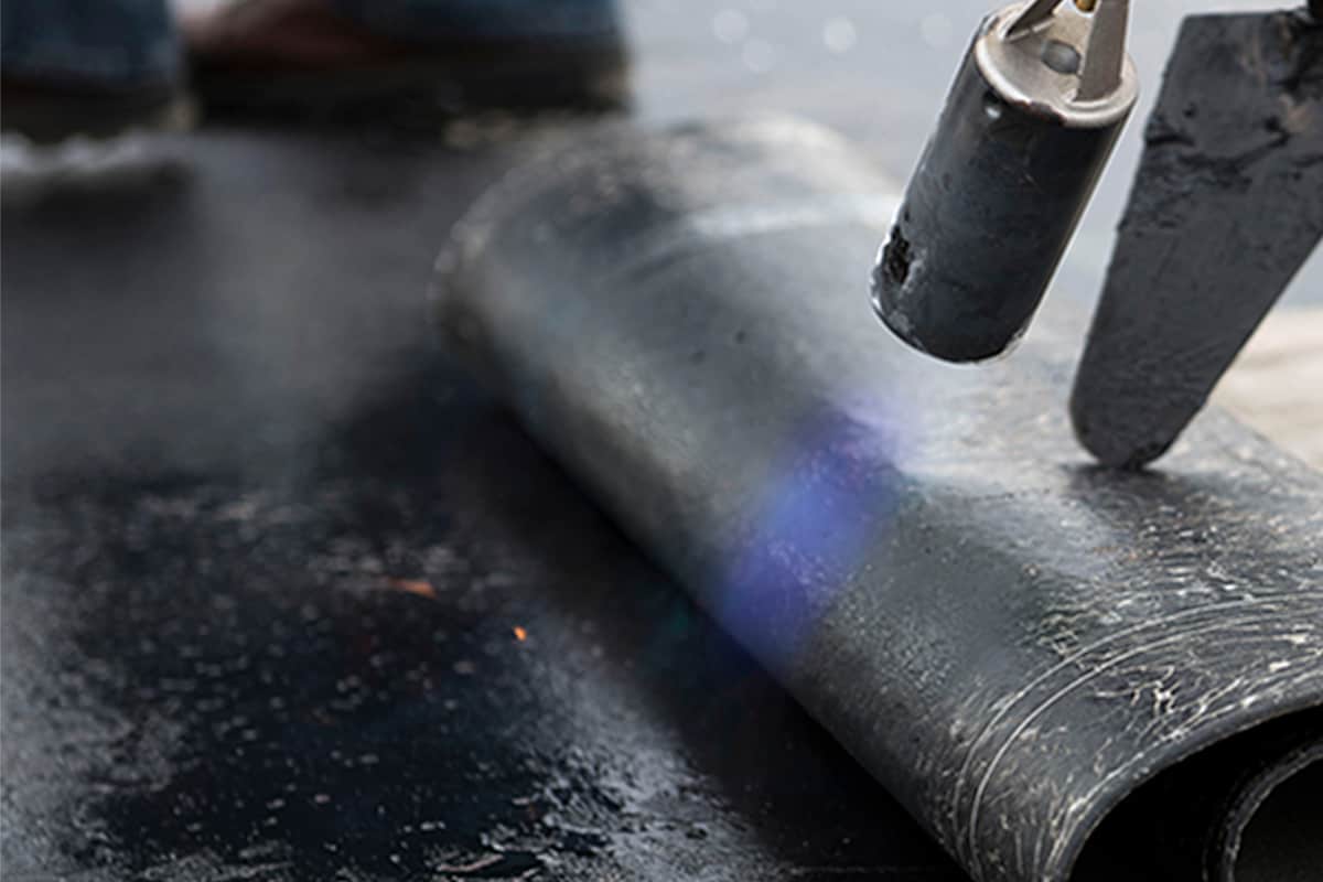 a roofing contractor installing a torched membrane 