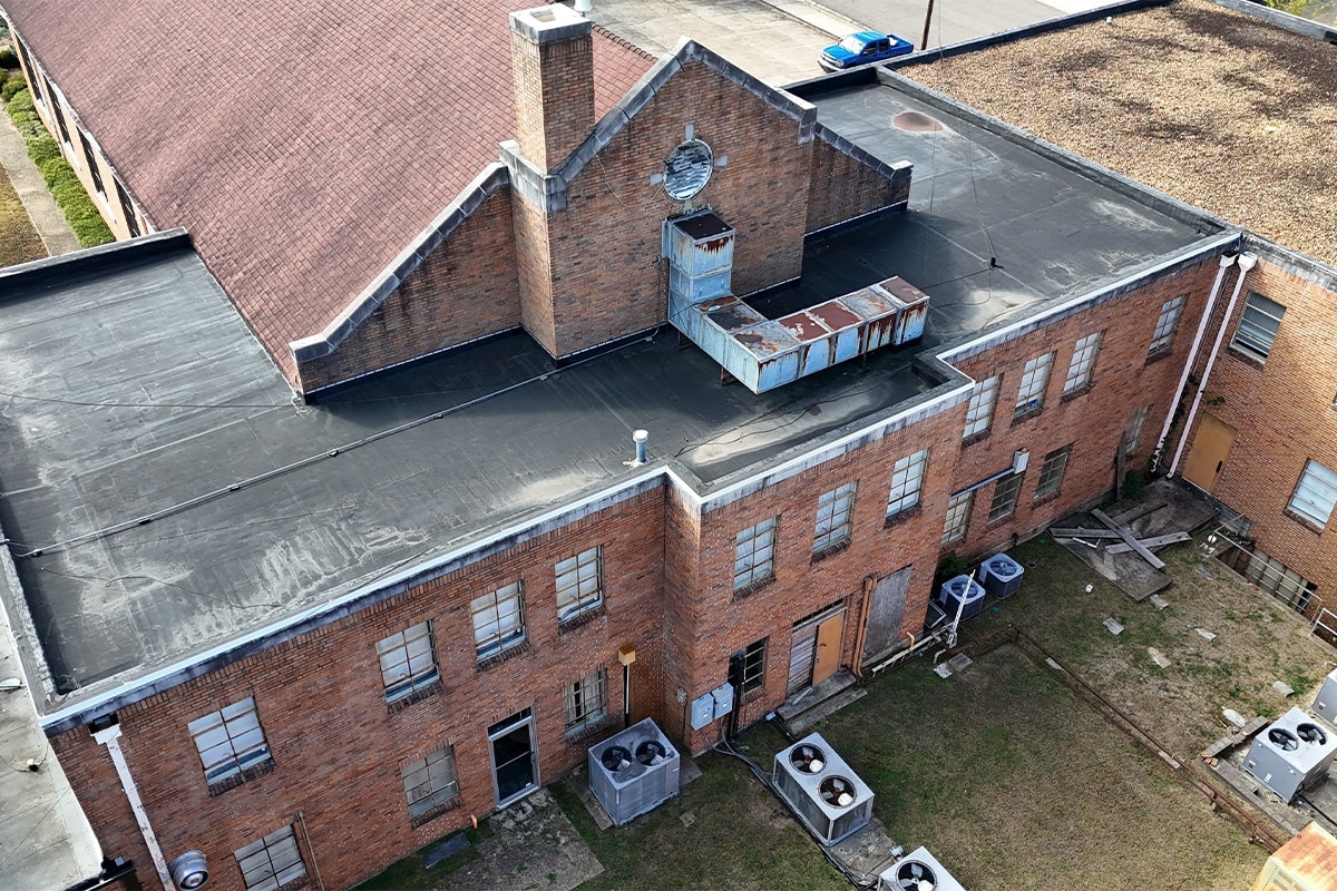 Before image of the aging roofs with varying flat roof materials at the Link Centre in Tupelo, MS.