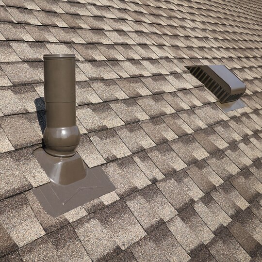 A close-up view of an asphalt shingle roof featuring GAF roof accessories that can help reduce water penetration.