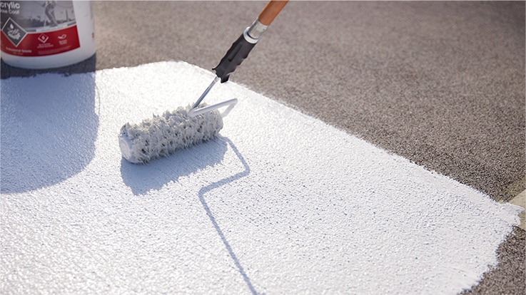 Contractor rolling coating on flat roof