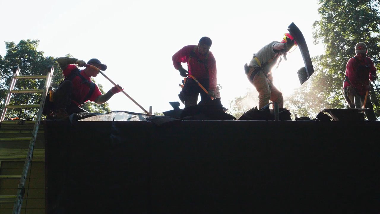 Contractors removing old roof shingles