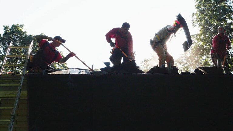 Contractors removing old roof shingles