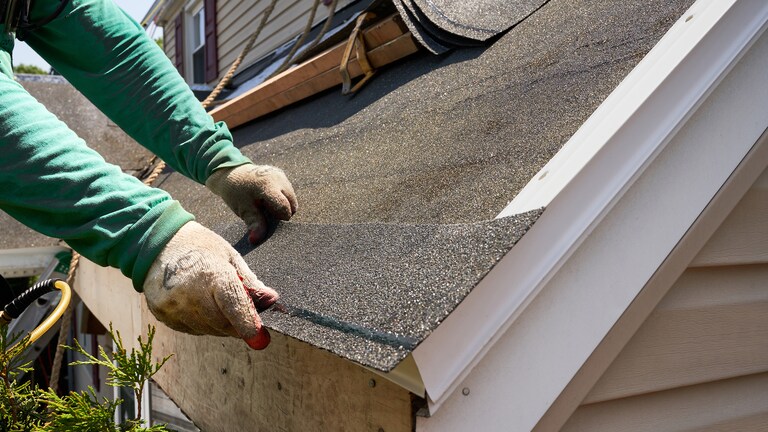 Video thumbnail image showing a contractor applying GAF strip shingles onto a roof. 