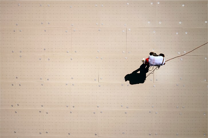 Aerial shot of a GAF contractor installing EnergyGuard™ HD-MA Polyiso cover board to a low-slope roof