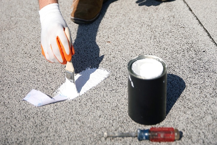 Contractor applying coating with a brush