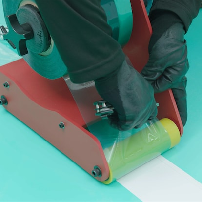 A roofing contractor cut the seam film with a knife to separate it from the MembraneShield™ Seam Film Applicator. 
