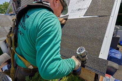 Fastening starter strip shingle with pneumatic nailer above roof eave.