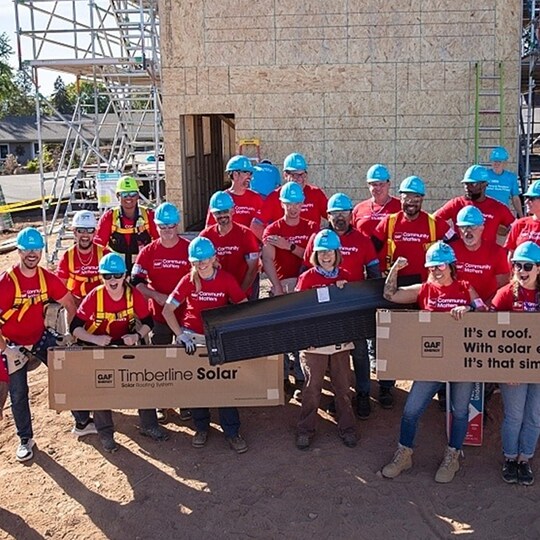 GAF employees posting at the Carter Work Project construction site and holding up Timberline brand products