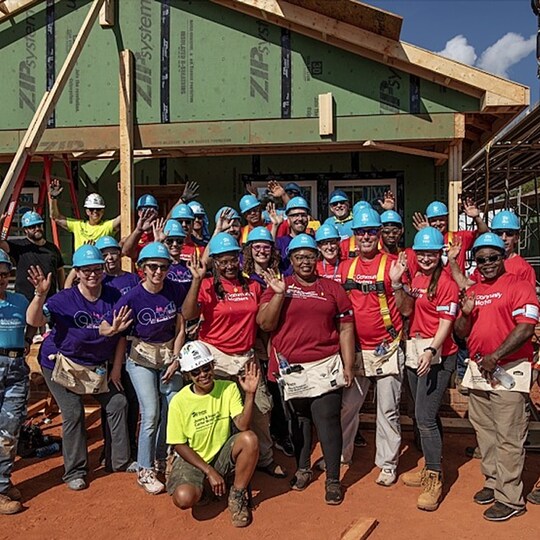 View of volunteers from GAF wearing hard hats at a construction site