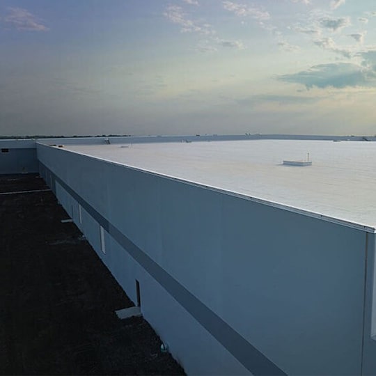  An aerial shot of a large commercial building with a flat roof.