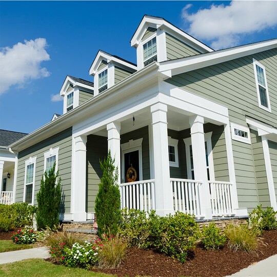 A view of a house with a new roof, siding, and windows installed by Feazel
